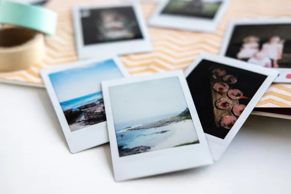 Polaroid photos of travel memories scattered on a desk